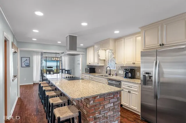 a kitchen with refrigerator a sink and chairs