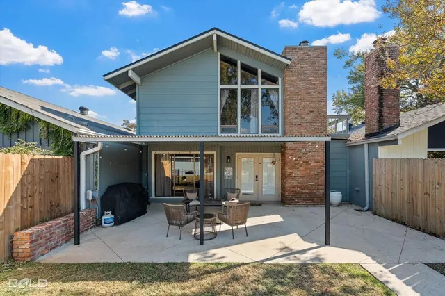 a view of a patio with a table and chairs and potted plants