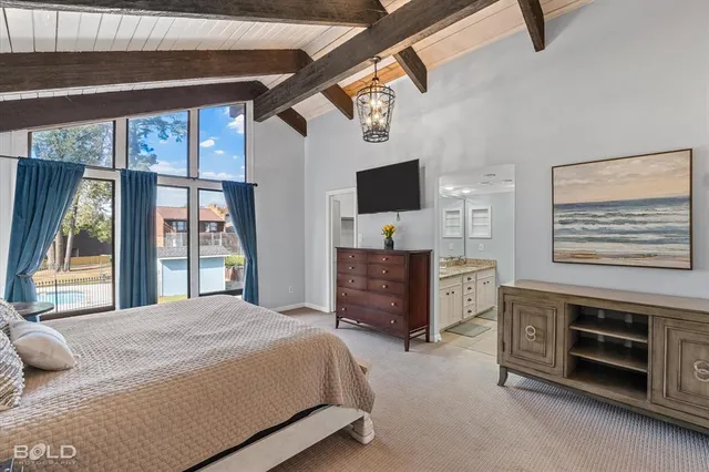 a bedroom with a bed dresser and a flat tv screen