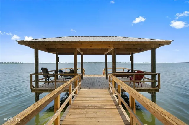 a view of a balcony with chairs and wooden floor