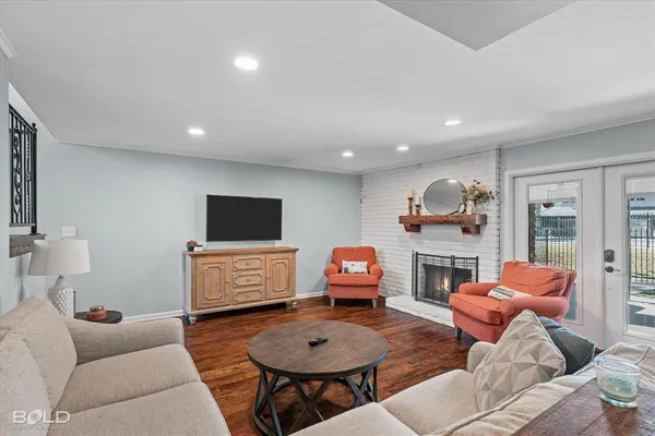 a living room with furniture a flat screen tv and a window