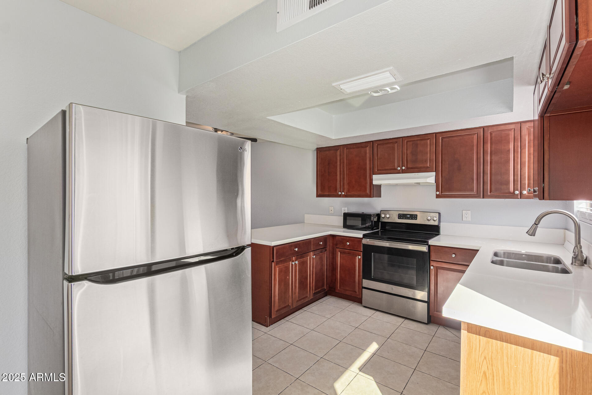 548 South Wilson Street, Unit 104 Tempe, AZ 85281 - Photo 5 of 18 a kitchen with stainless steel appliances granite countertop a refrigerator sink stove and microwave