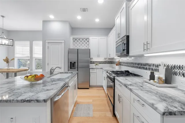 a kitchen with stainless steel appliances granite countertop a sink stove and refrigerator