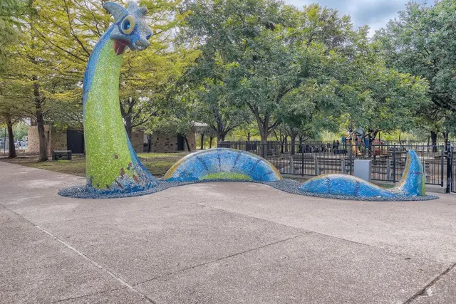 a view of a house with a yard and a large tree