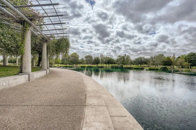 a view of a lake with a yard and large trees