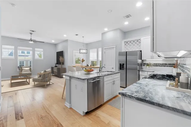 a kitchen with stainless steel appliances granite countertop a sink stove and refrigerator