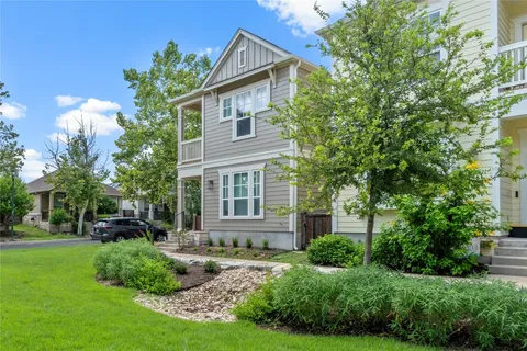a front view of a house with a yard and potted plants