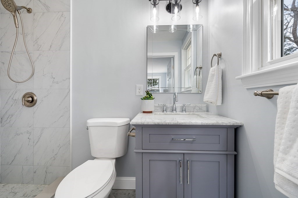217 Marked Tree Road Holliston, MA 01746 - Photo 19 of 30 a bathroom with a granite countertop toilet sink and mirror