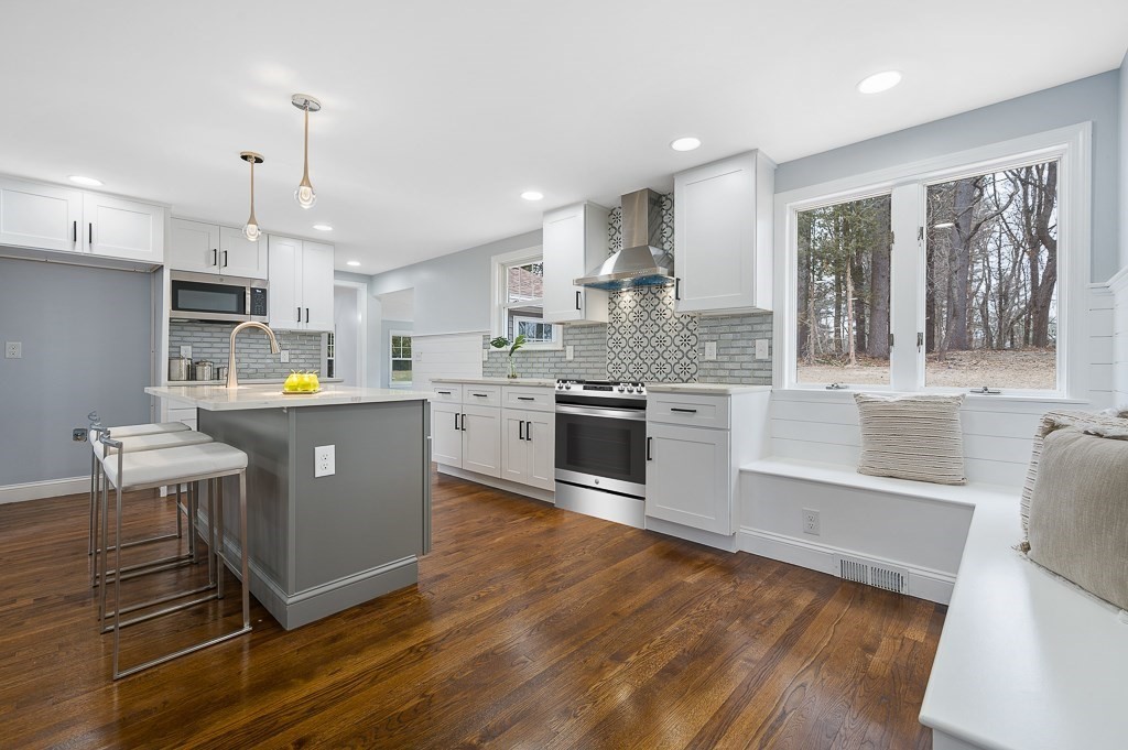 217 Marked Tree Road Holliston, MA 01746 - Photo 9 of 30 a kitchen with kitchen island granite countertop a sink cabinets and wooden floor