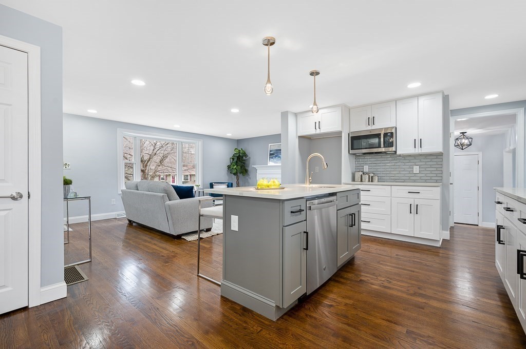 217 Marked Tree Road Holliston, MA 01746 - Photo 10 of 30 a kitchen with kitchen island granite countertop a sink cabinets and wooden floor