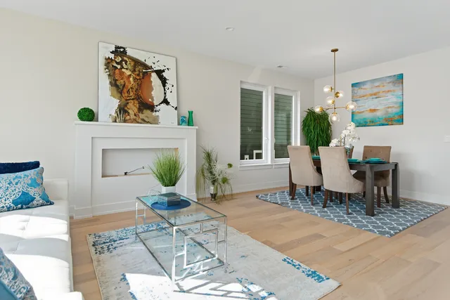 a living room with furniture a dining table and a potted plant