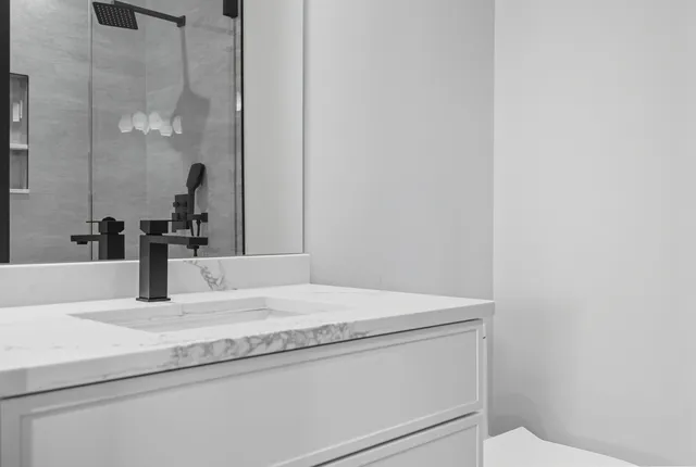 a bathroom with a granite countertop sink vanity and toilet