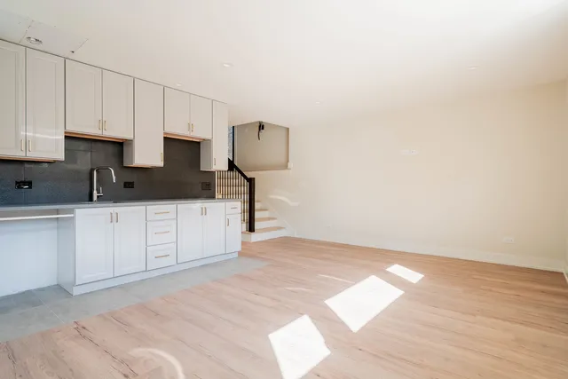 a kitchen with granite countertop a sink a stove and cabinets