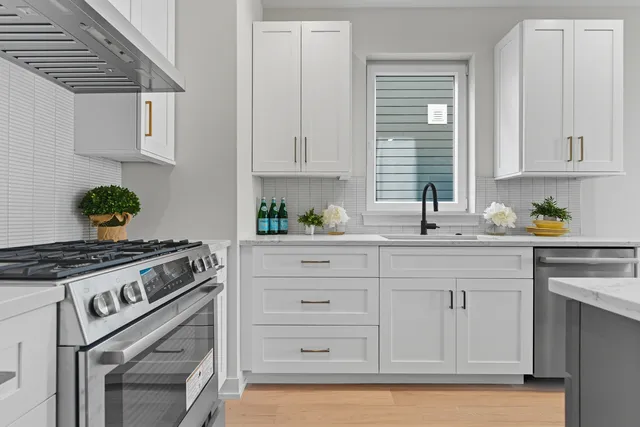 a kitchen with white cabinets and appliances