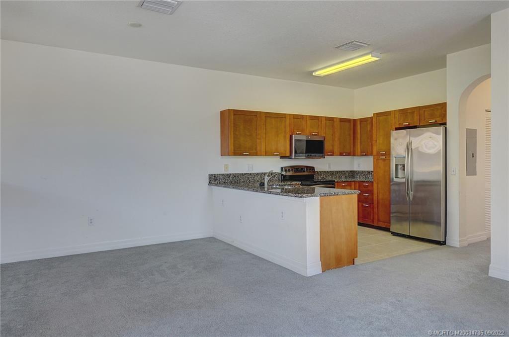 63 Southeast Palermo, Unit 202 Stuart, FL 34994 - Photo 13 of 30 a kitchen with refrigerator and microwave