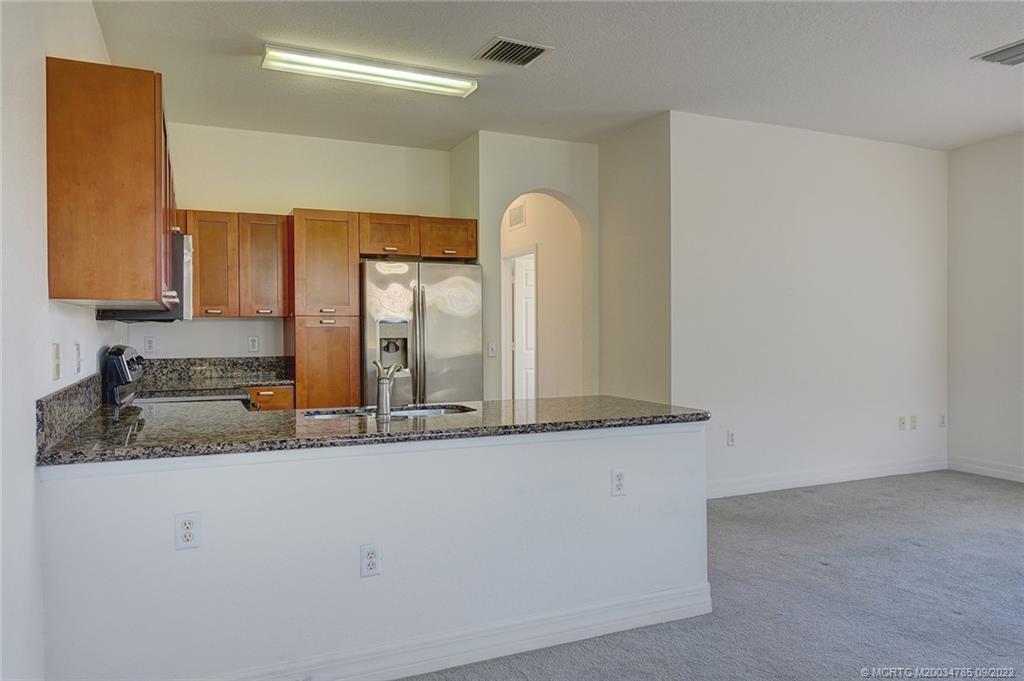 63 Southeast Palermo, Unit 202 Stuart, FL 34994 - Photo 14 of 30 a bathroom with a granite countertop sink and a mirror