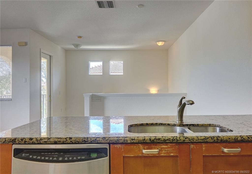 63 Southeast Palermo, Unit 202 Stuart, FL 34994 - Photo 23 of 30 a kitchen with granite countertop a stove and cabinets