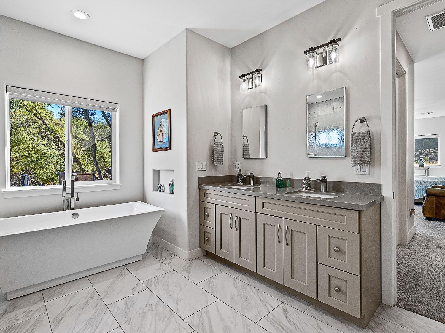 3102 Squirrel Hollow Mount Aukum, CA 95656 - Photo 17 of 51 a spacious bathroom with a double vanity sink a large mirror and a bathtub