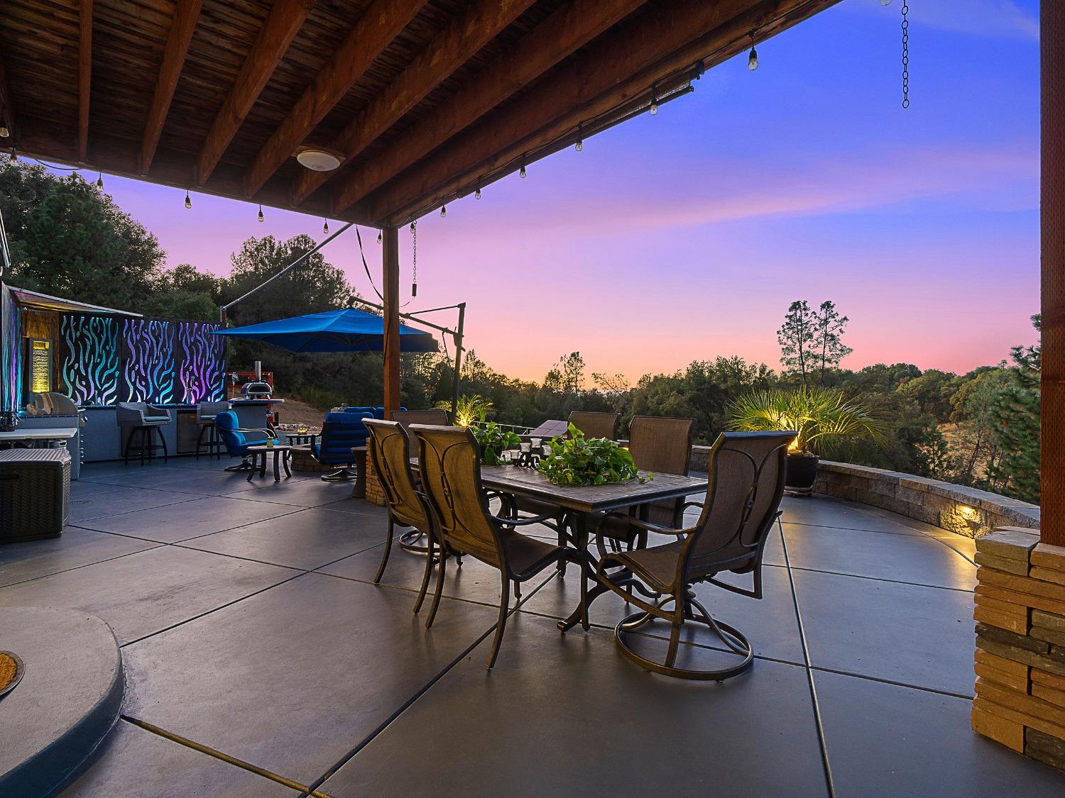 3102 Squirrel Hollow Mount Aukum, CA 95656 - Photo 33 of 51 a view of a patio with table and chairs under an umbrella with a barbeque