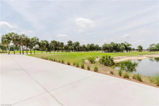 a view of a lake with a big yard and large trees