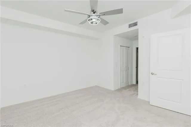 an empty room with a ceiling fan and a window