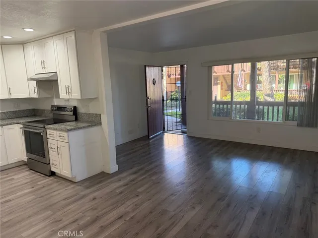 a kitchen with stainless steel appliances granite countertop a stove a sink and a wooden floors