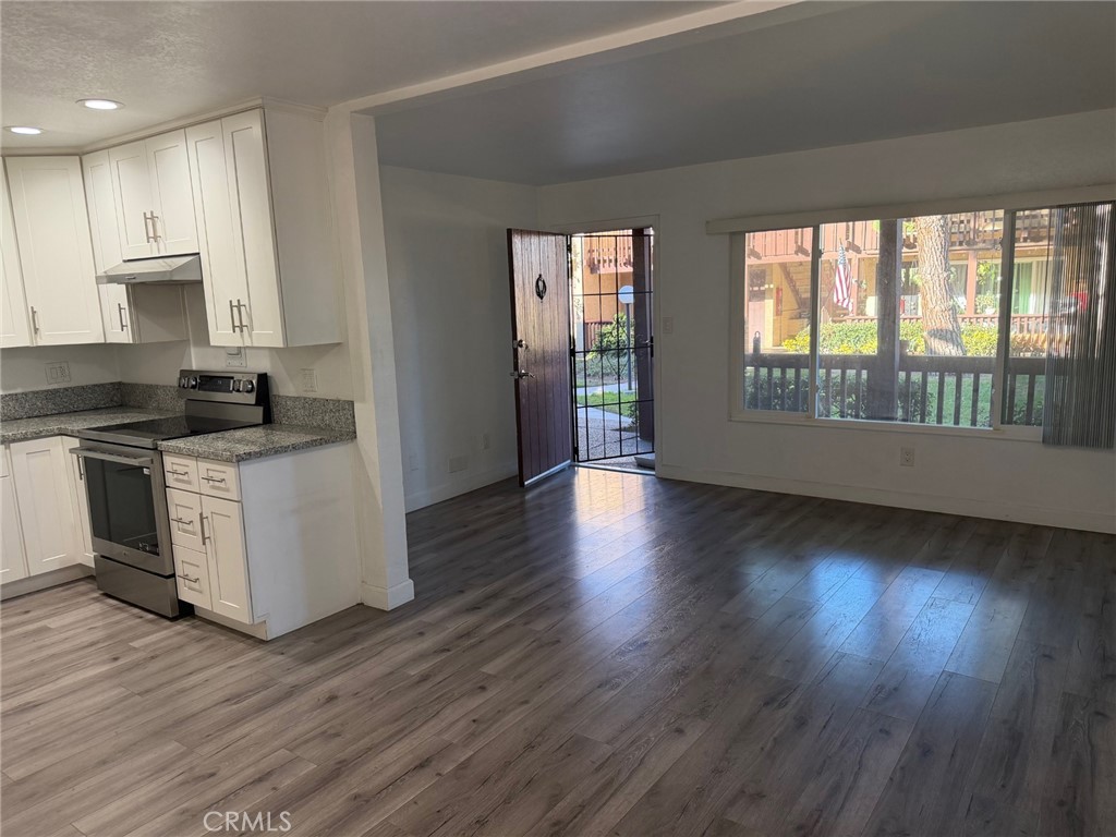 1010 West MacArthur Boulevard, Unit 147 Santa Ana, CA 92707 - Photo 4 of 12 a kitchen with stainless steel appliances granite countertop a stove a sink and a wooden floors