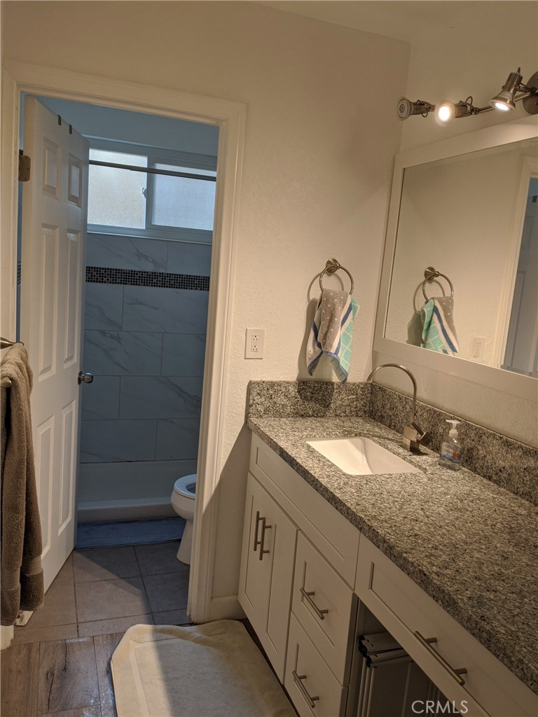 1010 West MacArthur Boulevard, Unit 147 Santa Ana, CA 92707 - Photo 5 of 12 a bathroom with a granite countertop sink toilet and shower