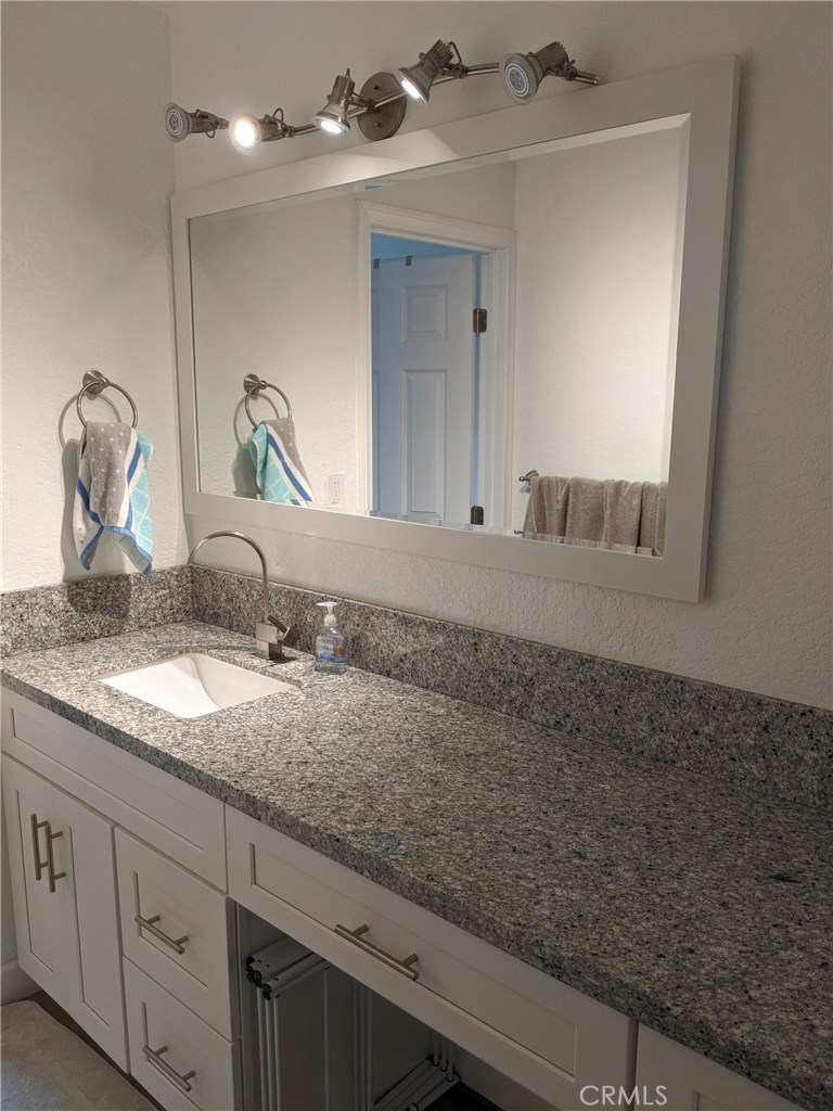 1010 West MacArthur Boulevard, Unit 147 Santa Ana, CA 92707 - Photo 6 of 12 a bathroom with a granite countertop sink and a mirror