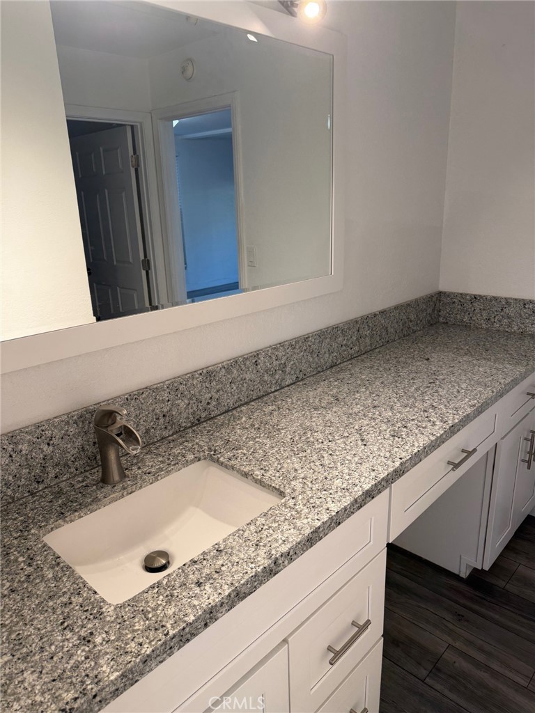 1010 West MacArthur Boulevard, Unit 147 Santa Ana, CA 92707 - Photo 7 of 12 a bathroom with a granite countertop sink and vanity