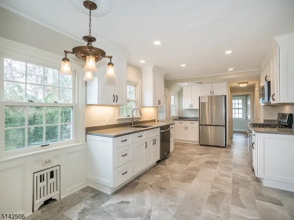 a kitchen with stainless steel appliances granite countertop a sink a stove and a refrigerator
