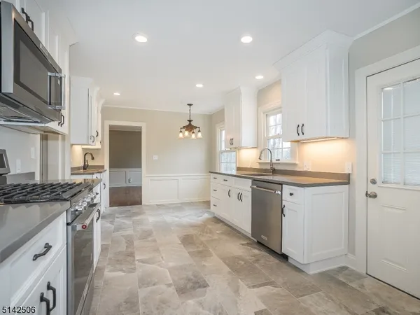 a kitchen with granite countertop cabinets stainless steel appliances and a counter space