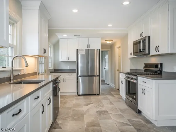 a kitchen with stainless steel appliances granite countertop a refrigerator sink and stove