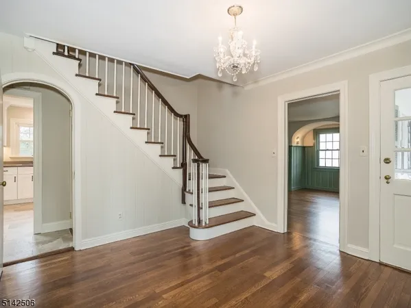 a view of a hallway with wooden floor and staircase