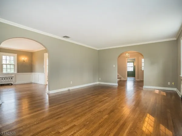 a view of empty room with wooden floor and window