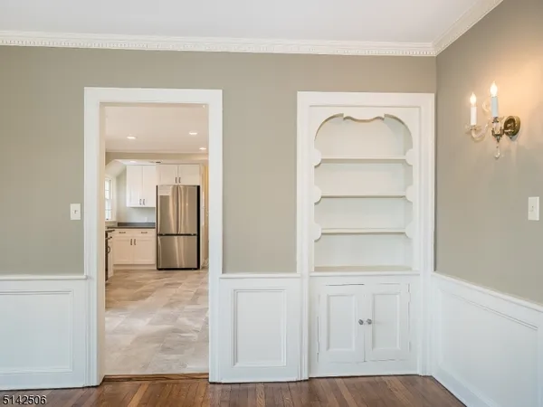 a view of a hallway with wooden floor and cabinet