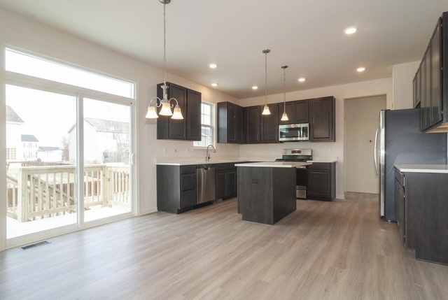 3118 Patterson Road Montgomery, IL 60538 - Photo 4 of 23 a large kitchen with stainless steel appliances kitchen island a large counter top a sink a counter space and wooden floor