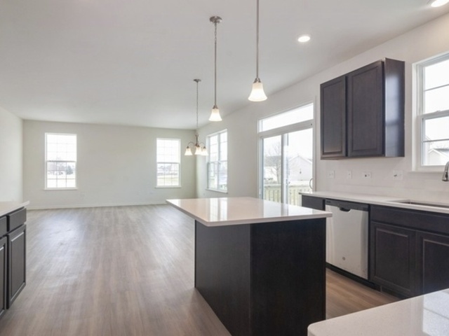 3118 Patterson Road Montgomery, IL 60538 - Photo 10 of 23 a kitchen with stainless steel appliances granite countertop wooden cabinets a sink dishwasher a stove and a refrigerator with wooden floor