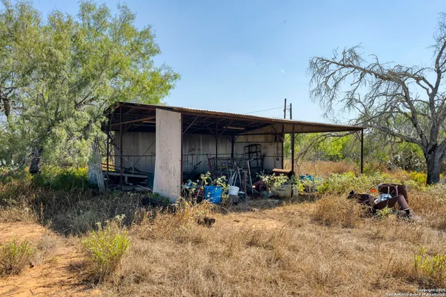 a backyard of a house with yard table and chairs