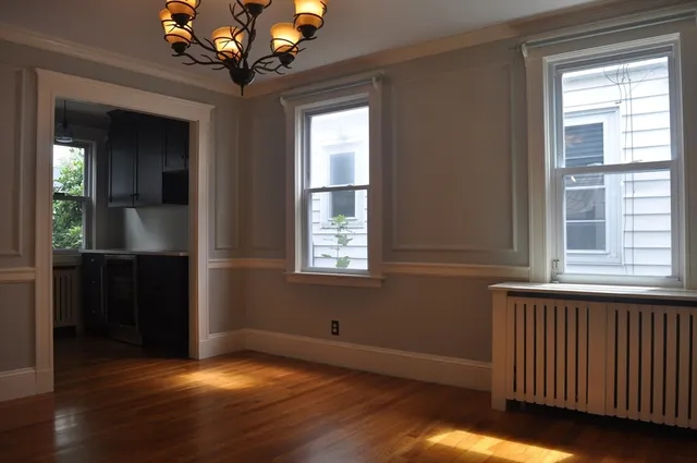 a view of a hallway with wooden floor and a chandelier