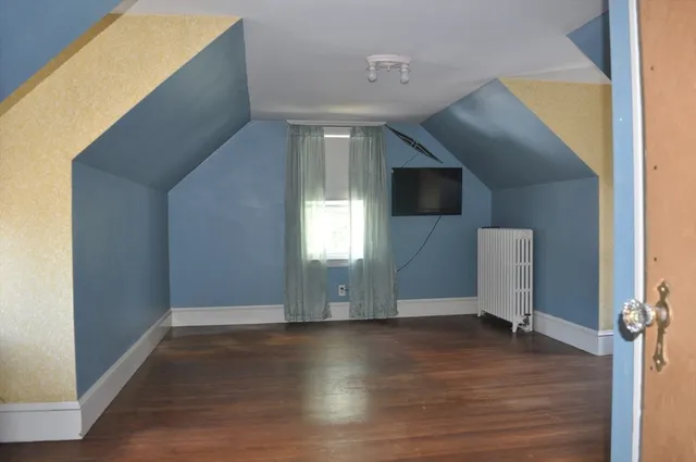 a view of a livingroom with wooden floor and window