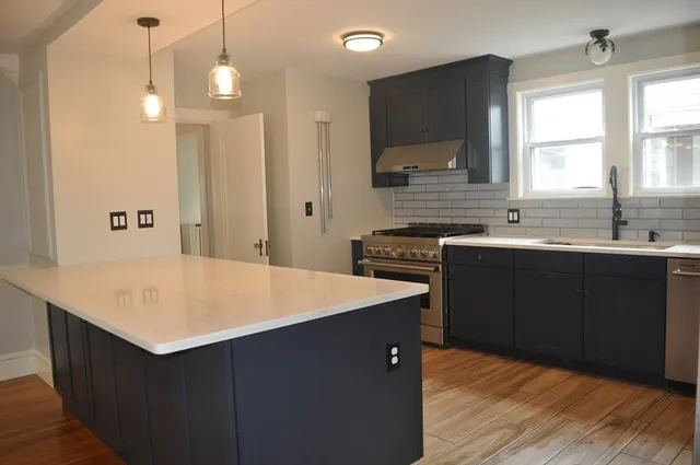 a kitchen with a sink a stove a refrigerator and a microwave