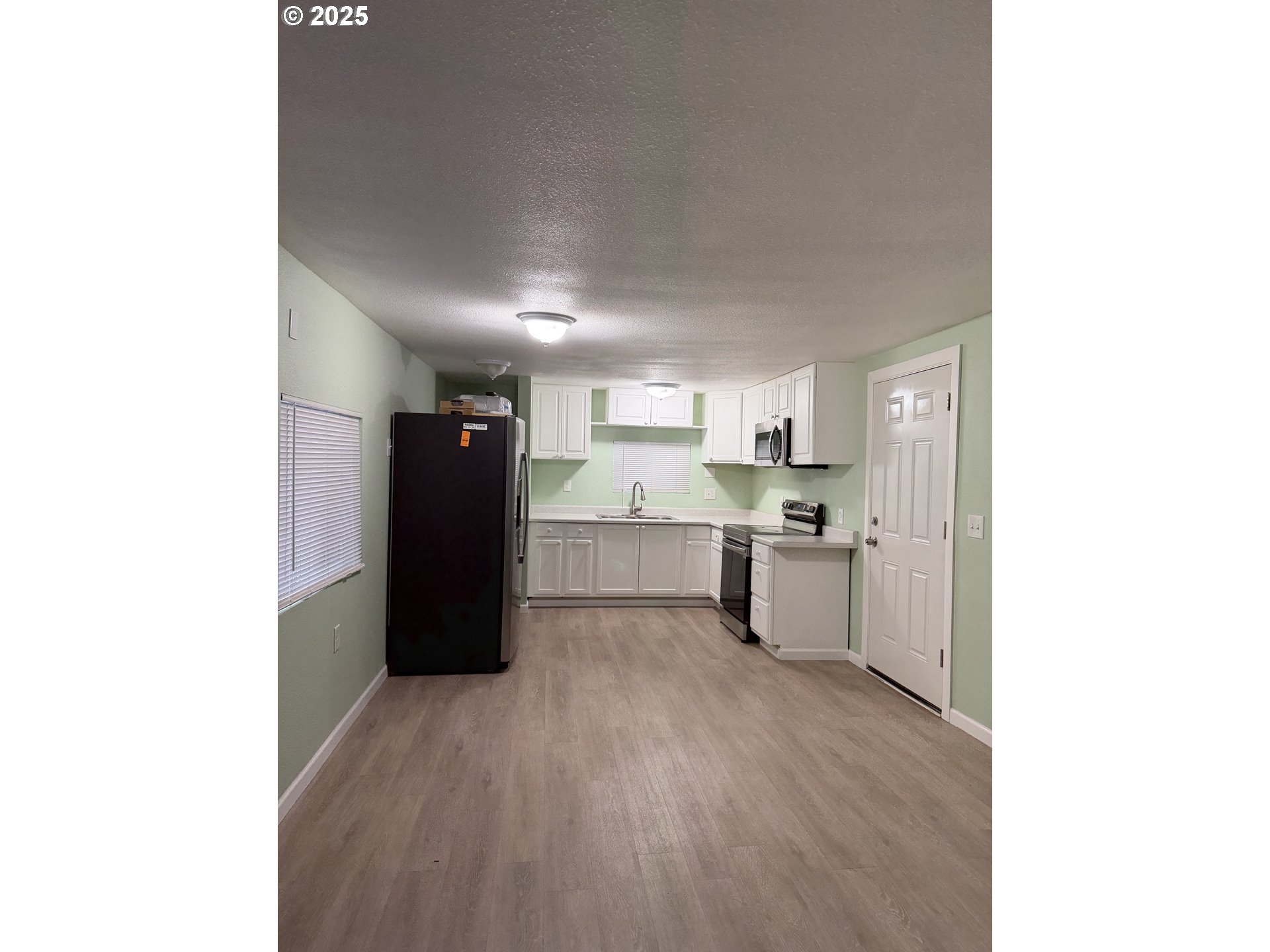 7409 Southeast 82nd Avenue, Unit 4 Portland, OR 97266 - Photo 10 of 15 a kitchen with a refrigerator and a stove top oven