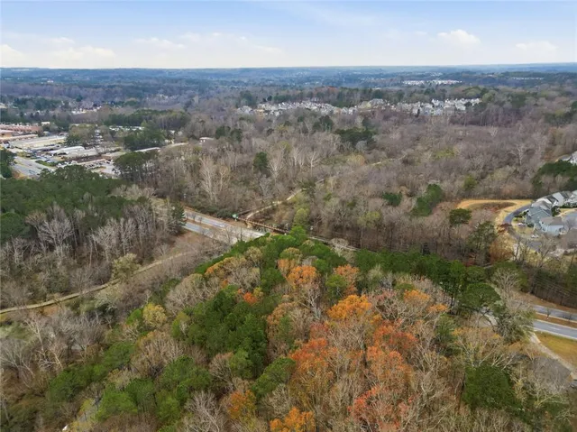 an aerial view of residential houses with outdoor space and trees