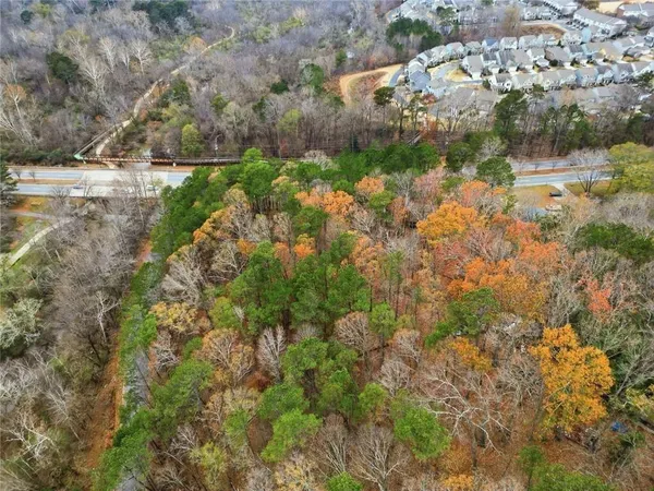 an aerial view of residential houses with outdoor space and trees