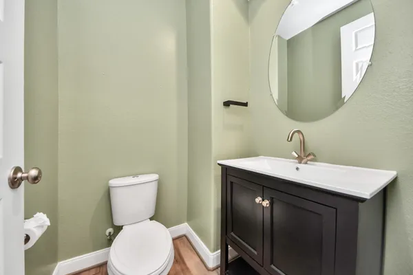 a bathroom with a toilet a sink and mirror