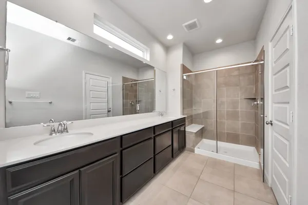 a bathroom with a double vanity sink toilet and shower
