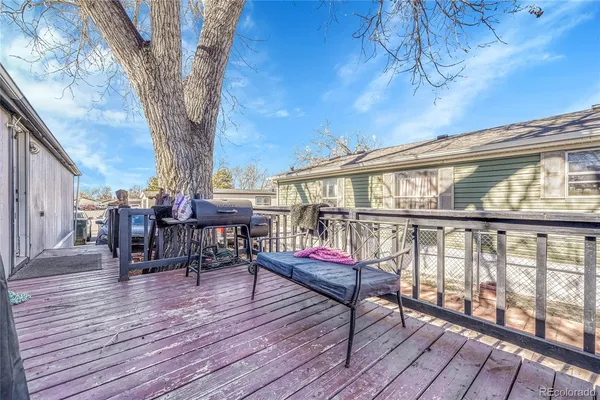 a balcony with wooden floor table and chairs