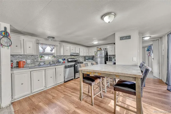 a large kitchen with kitchen island a table and chairs in it
