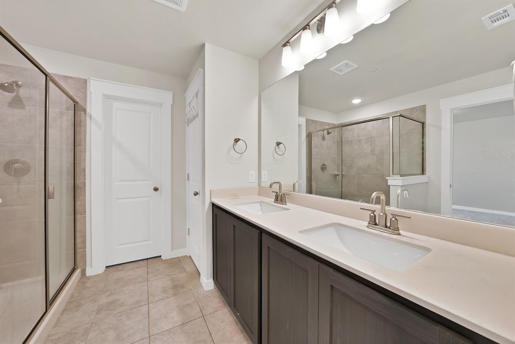 6610 Baritone Court Sachse, TX 75048 - Photo 20 of 30 a bathroom with a double vanity sink and a mirror